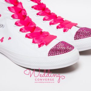White high trainer with bright pink laces, sparkly pink toes, pink hearts on the side and personalised with date or name